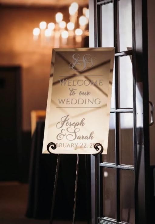 Personalized mirrored welcome sign displayed at a wedding